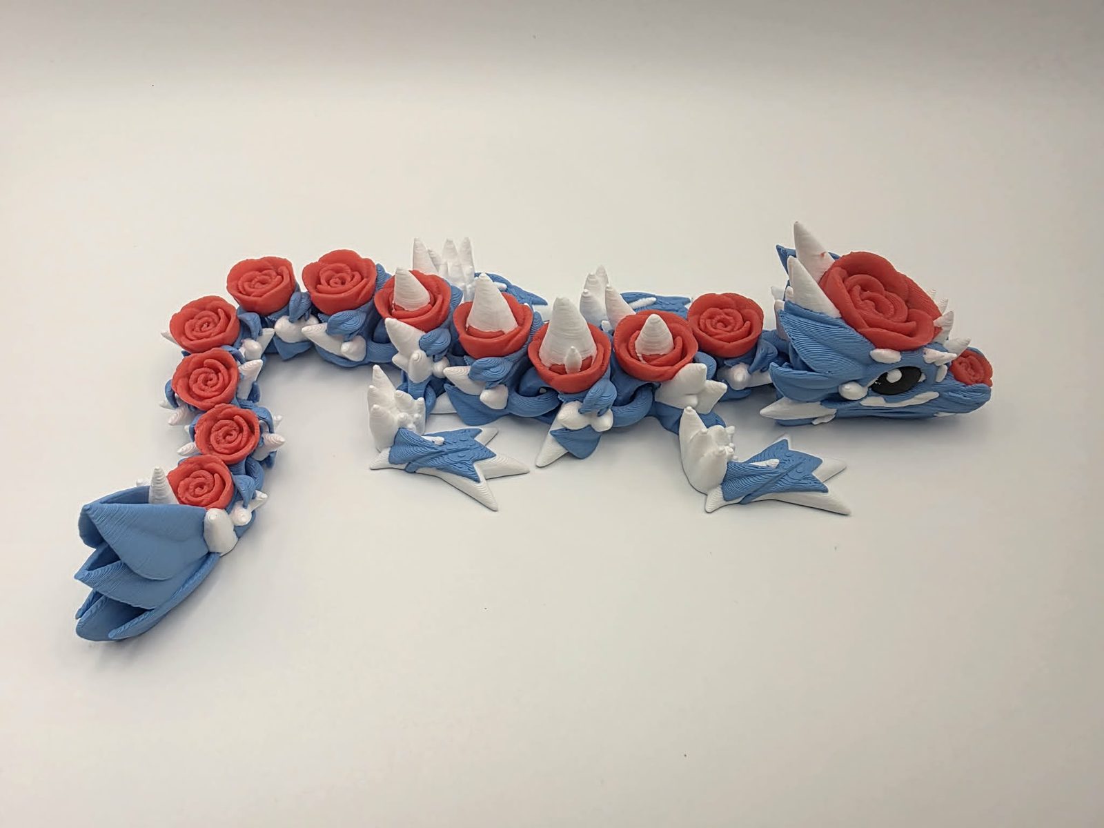 Rose Dragon - Sky Rose Dragon - 10" Long x 3" Wide Outer Foot to Outer Foot x 1.5" Tall - Sky Blue, White, Cherry Red, Black 3D printed item image