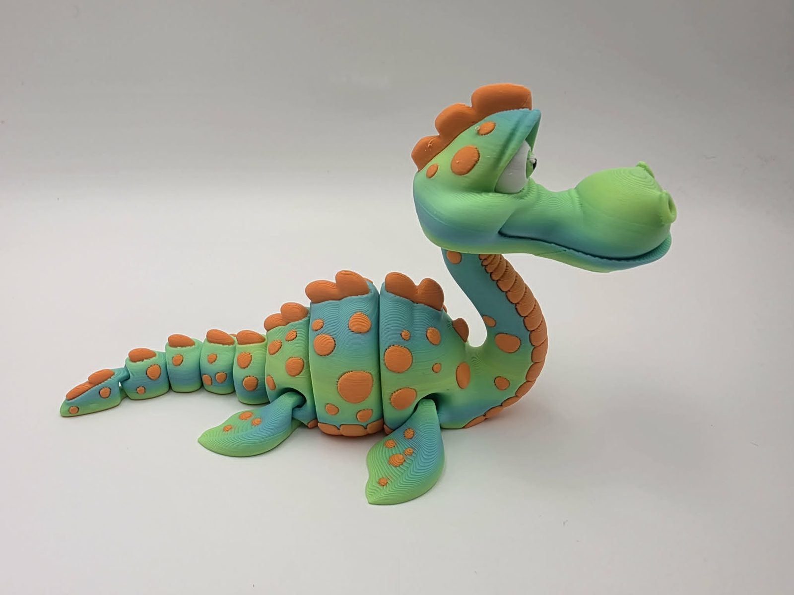 Loch Ness Monster - Nessy - 6" Long x 3" Wide Fin to Fin x 3" Tall - Matte Yellow Green Rainbow, Sunny Orange, White, Black 3D printed item image